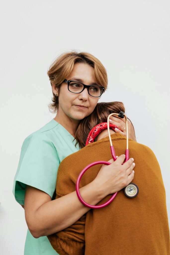 A caring doctor in scrubs consoling a distressed patient with a stethoscope.